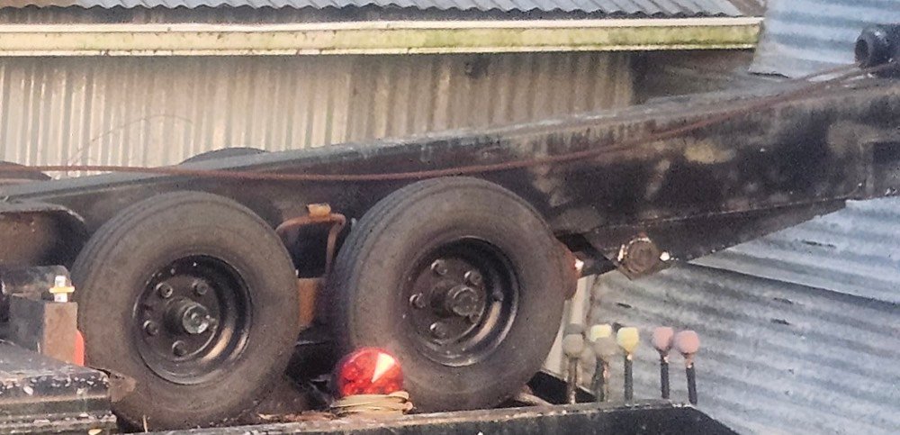 The boom and wheel-lift on the back of the wrecker, chains hanging.
