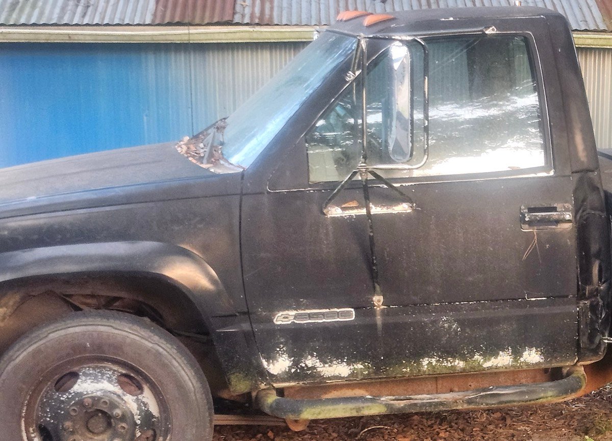 The cab and front dually wheel of the black boom wrecker.