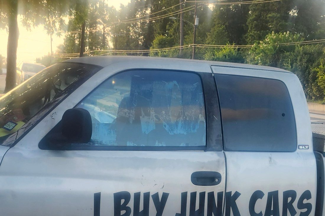 The pickup at sunrise, side on, boom folded down over the bed.